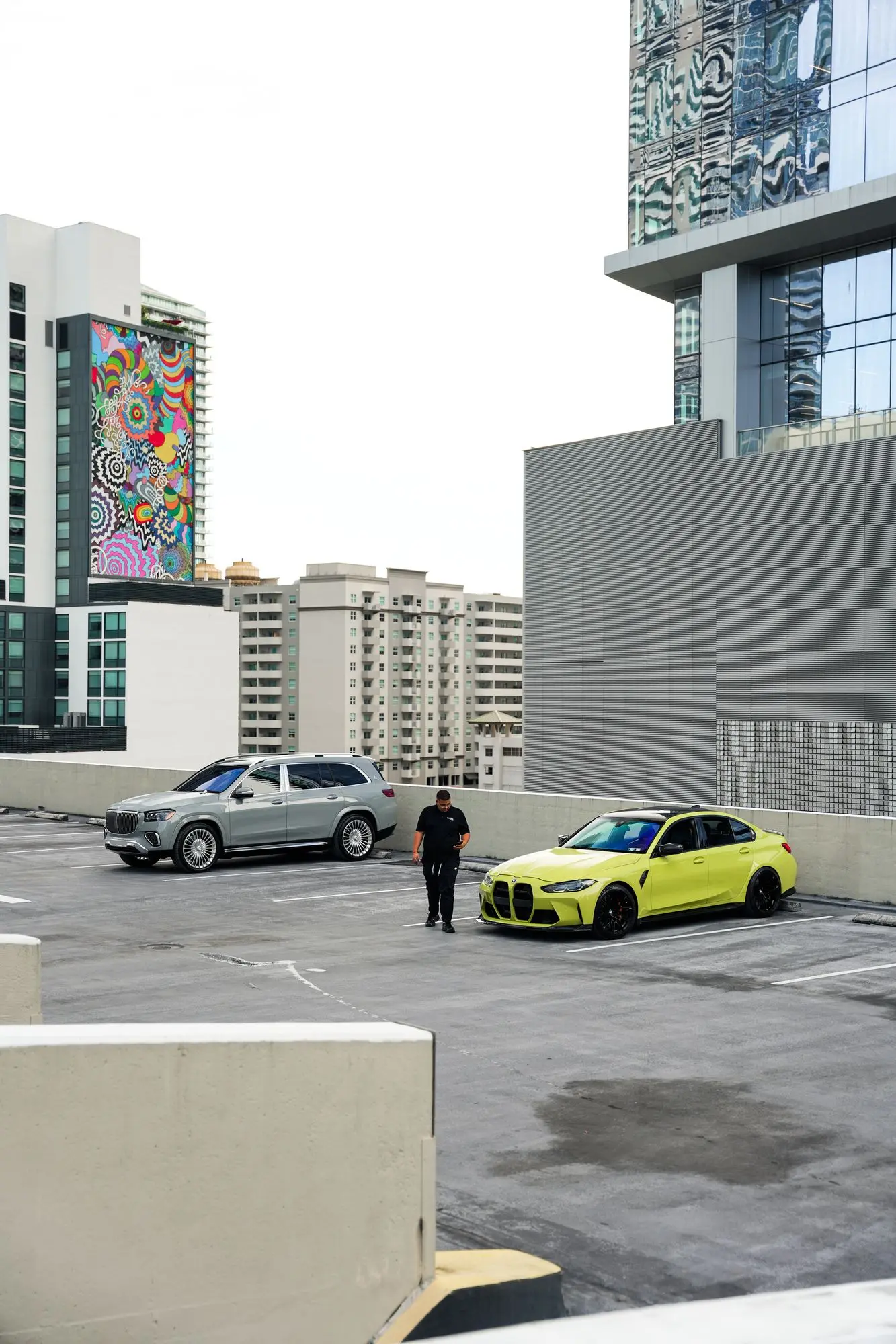 A fleet specialist handing over a BMW M3 on a Miami rooftop